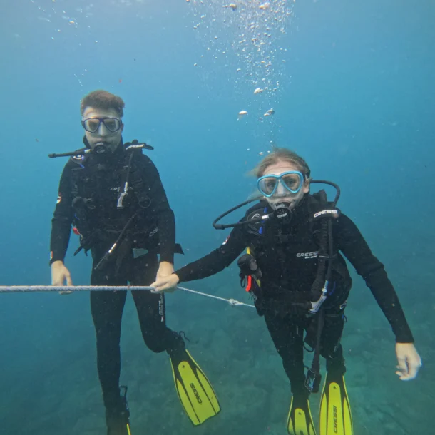 PADI Open Water Diver students practicing underwater skills while descending along a guide line