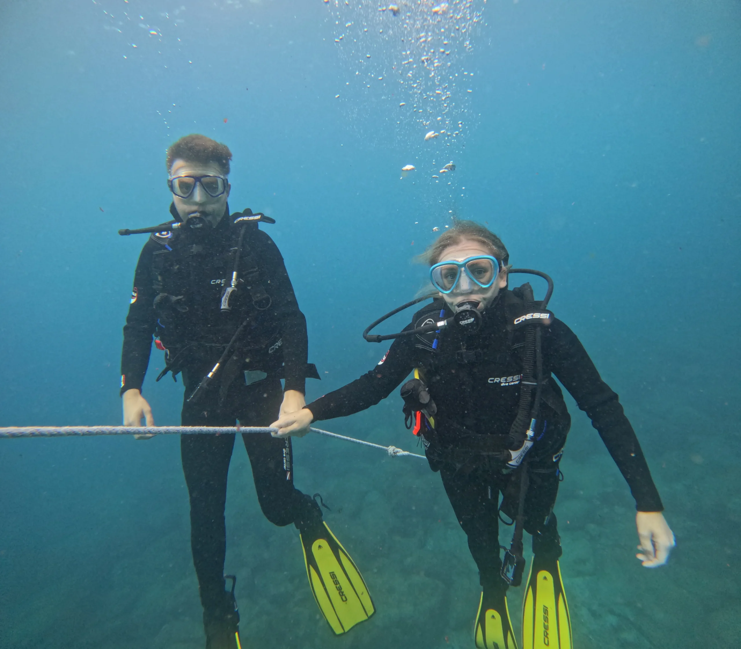 PADI Open Water Diver students practicing underwater skills while descending along a guide line